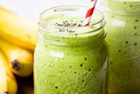 A close up photo of a green smoothie in a Mason jar.